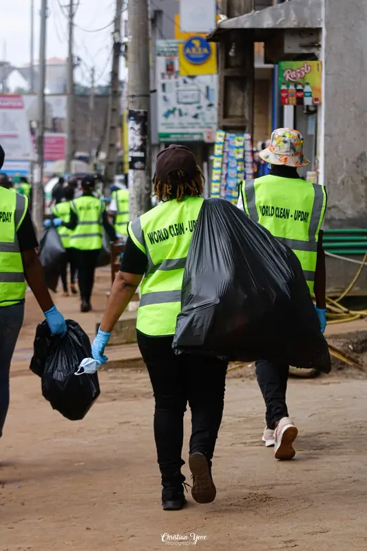 Des bénévoles transportent les sacs de déchets collectés dans la rue.